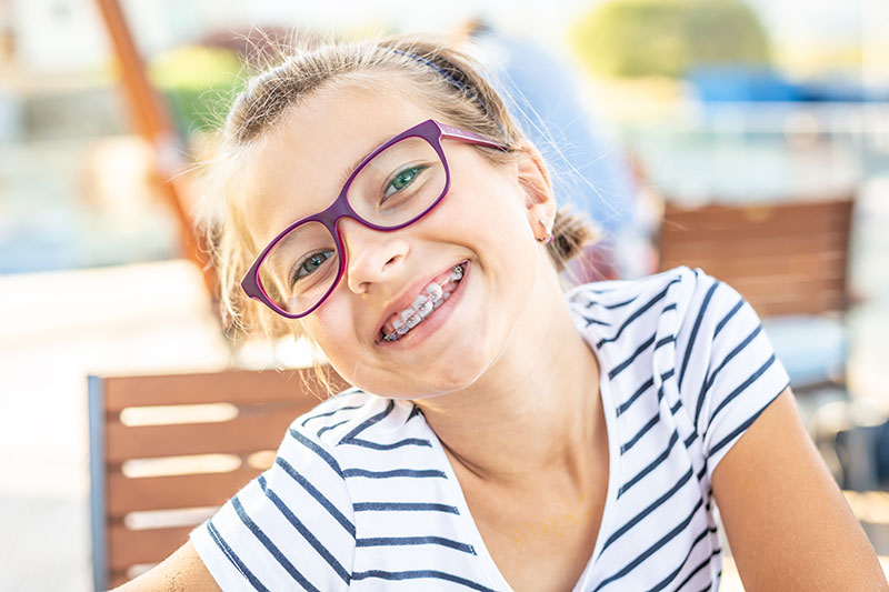 smiling girl with glasses and braces