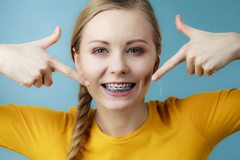 smiling girl pointing to her braces